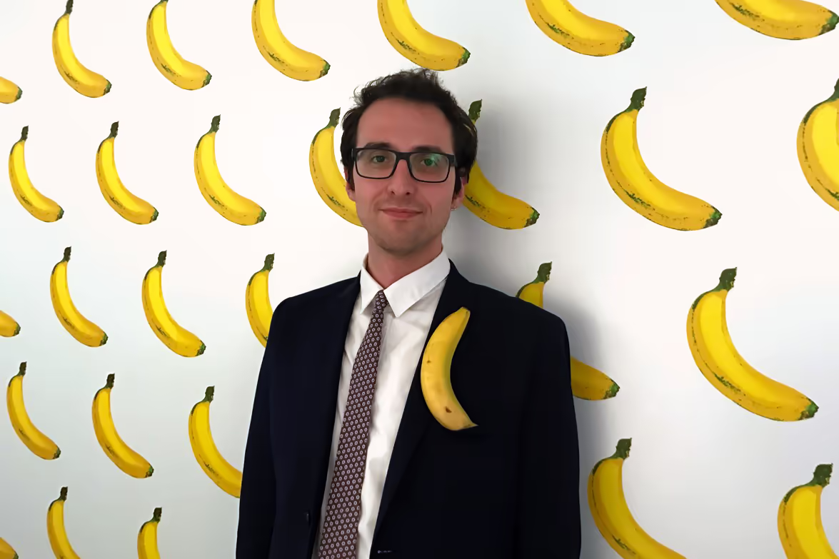 Igor Korenfeld in front of a banana wallpaper with a banana